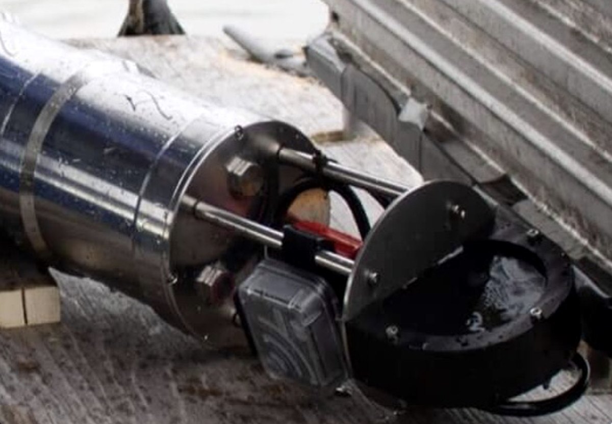 Stainless steel acoustic deterrent with a black emitter head on a vessel deck