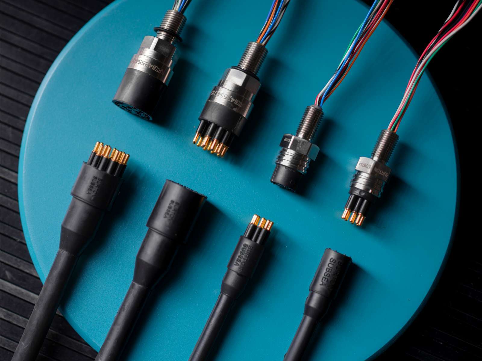Subsea power and data connectors on a teal background